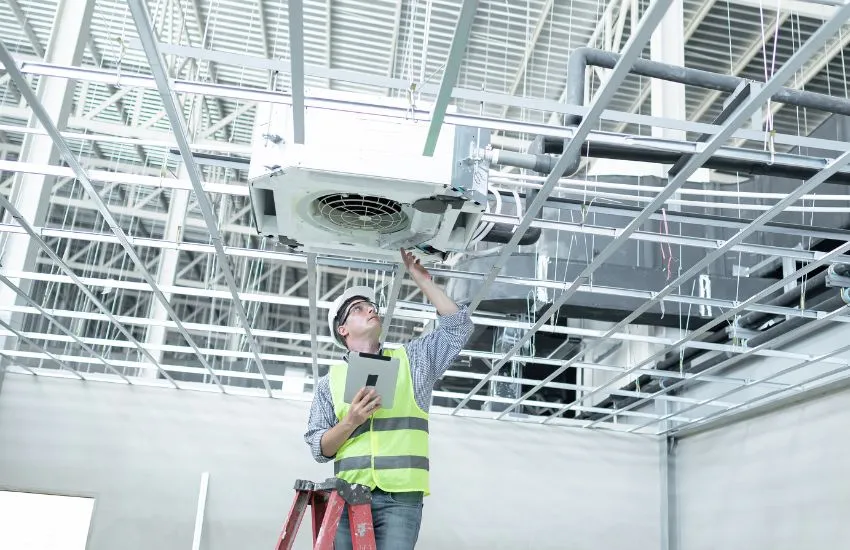 Hombre instalando un aire acondicionado industrial