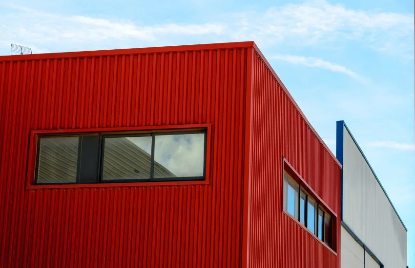 Fachada de una nave industrial moderna, con un diseño específico para reducir el calor en naves de producción.